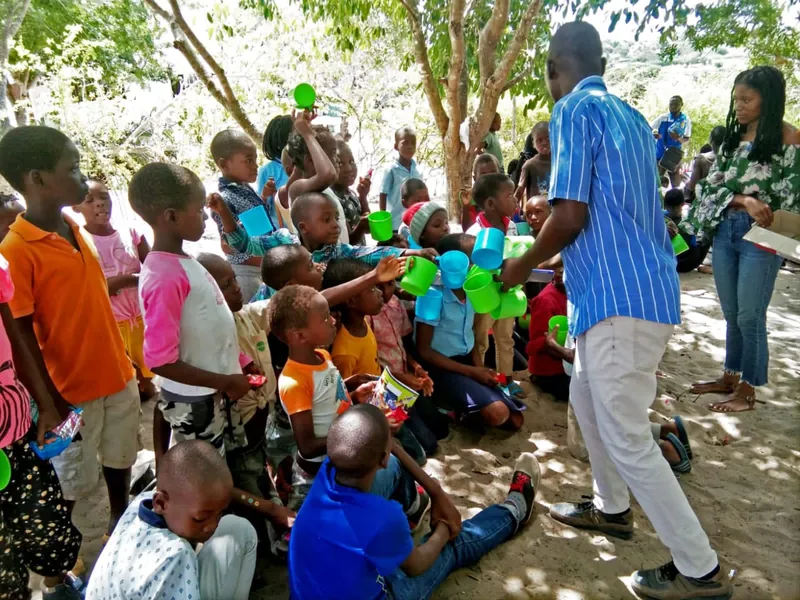 Crianças e adultos reunidos numa actividade comunitária de protecção à criança